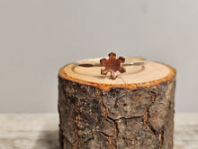 Load image into Gallery viewer, A sterling silver ring with a copper-colored flower-shaped design on a wooden surface.