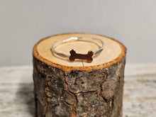 Load image into Gallery viewer, A sterling silver ring with a dog bone design, displayed on a wooden surface.