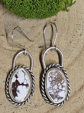 Load image into Gallery viewer, A pair of silver hoop earrings with wild horse stone inlays, displayed against a wood background.