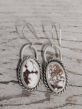 Load image into Gallery viewer, A pair of silver hoop earrings with wild horse stone inlays, displayed against a wood background.