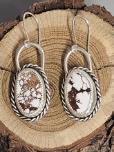 Load image into Gallery viewer, A pair of silver hoop earrings with wild horse stone inlays, displayed against a wood background.