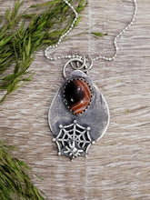 Load image into Gallery viewer, Silver-tone spider web necklace with oval dark stone pendant and lobster clasp