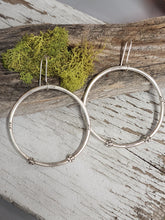 Load image into Gallery viewer, Large silver-tone hoop earrings with bead accents, paired on rustic wood