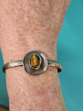 Load image into Gallery viewer, Silver-tone cowboy hat cuff bracelet with tiger eye oval stone on wrist
